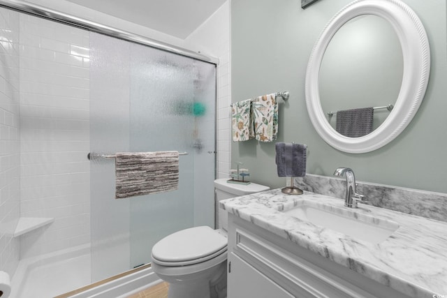 bathroom featuring a stall shower, vanity, and toilet