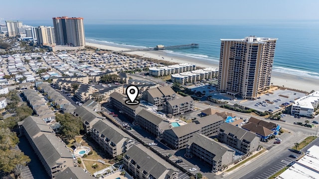 birds eye view of property featuring a water view, a view of the beach, and a city view