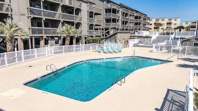 pool featuring fence and a patio