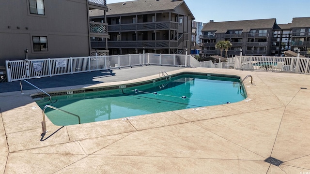 pool featuring fence and a patio