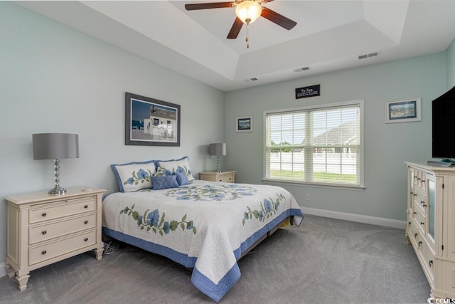 bedroom with a raised ceiling, carpet, baseboards, and ceiling fan