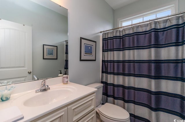 bathroom with toilet, vanity, and a shower with curtain