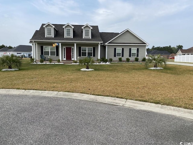 cape cod house with a front lawn, covered porch, and a shingled roof