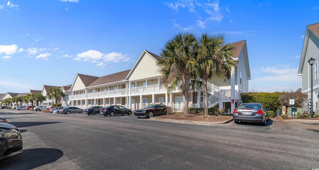 view of building exterior featuring a residential view and uncovered parking