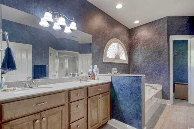 full bath featuring double vanity, a bath, a stall shower, and a sink