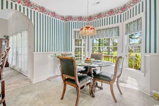 dining space with visible vents, baseboards, wallpapered walls, arched walkways, and tile patterned floors