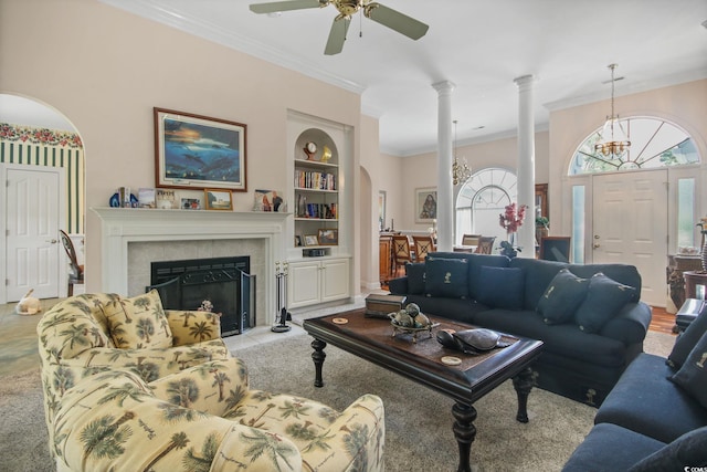 living area featuring built in shelves, a healthy amount of sunlight, decorative columns, and ornamental molding