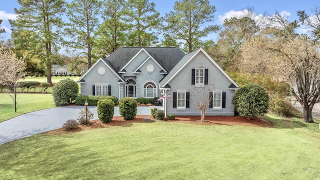 view of front of house featuring a front lawn, driveway, and stucco siding