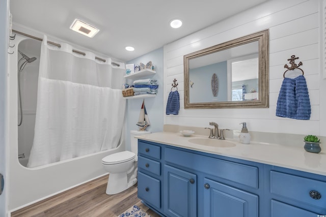 bathroom featuring recessed lighting, toilet, shower / bath combo, vanity, and wood finished floors