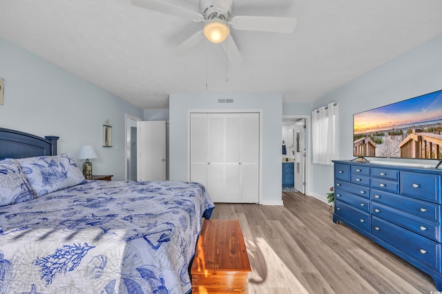 bedroom featuring ceiling fan, visible vents, baseboards, a closet, and light wood finished floors