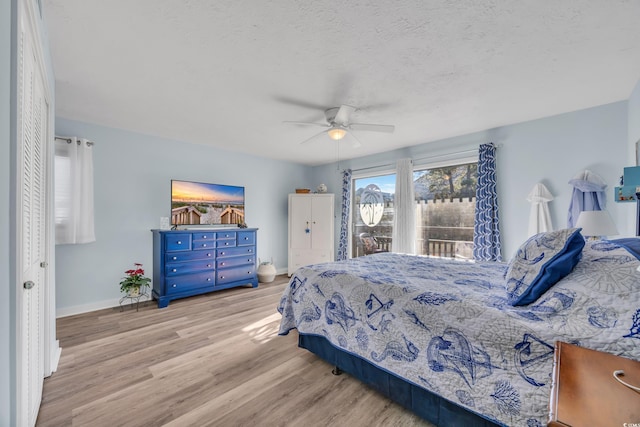 bedroom with a textured ceiling, wood finished floors, a ceiling fan, access to exterior, and baseboards