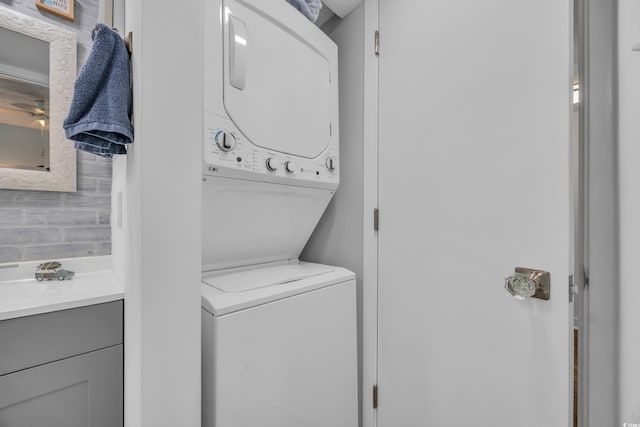 laundry area featuring stacked washer / dryer and ceiling fan