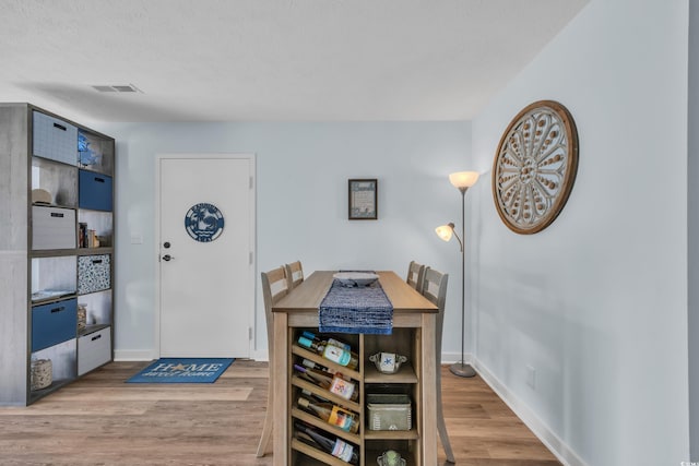 dining room with visible vents, baseboards, and wood finished floors