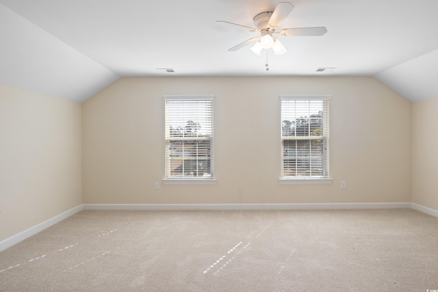 additional living space featuring carpet, lofted ceiling, visible vents, a ceiling fan, and baseboards