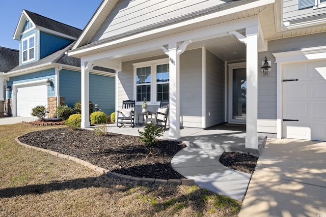 entrance to property with a garage, concrete driveway, a porch, and a shingled roof