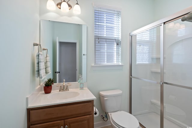 full bath featuring a shower with door, vanity, and toilet