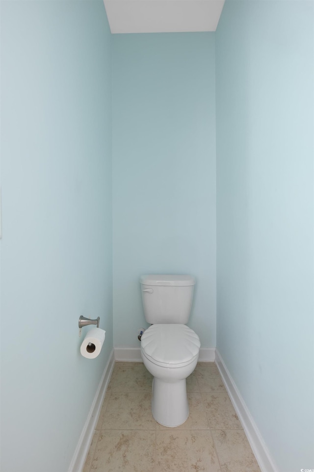 bathroom featuring tile patterned flooring, toilet, and baseboards