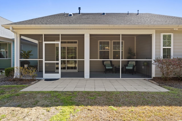 back of house featuring a sunroom and a shingled roof