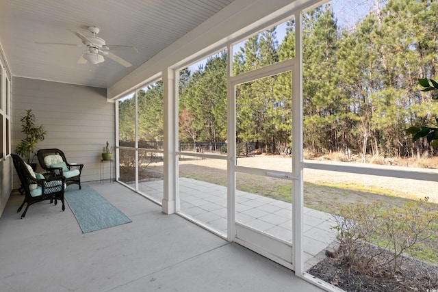 unfurnished sunroom featuring a ceiling fan