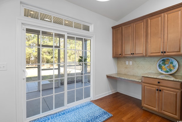 doorway to outside featuring lofted ceiling, dark wood-style floors, and baseboards