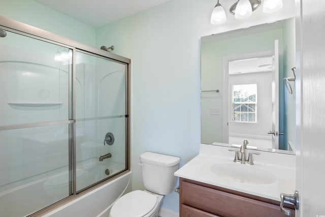 bathroom with shower / bath combination with glass door, vanity, and toilet