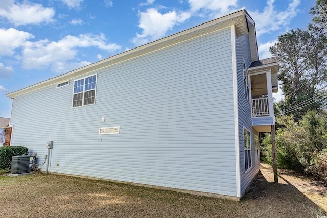 view of side of home featuring a lawn and central AC unit