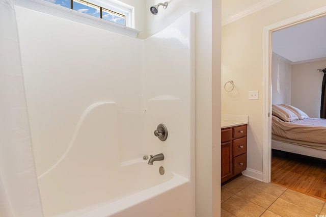 ensuite bathroom with tile patterned flooring, vanity, tub / shower combination, ensuite bath, and crown molding