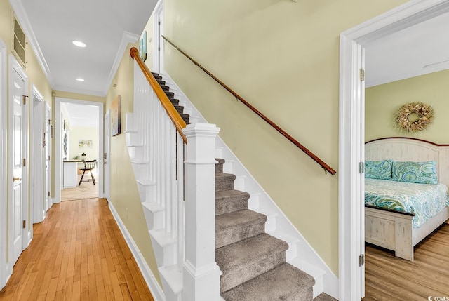 staircase with recessed lighting, baseboards, crown molding, and wood finished floors