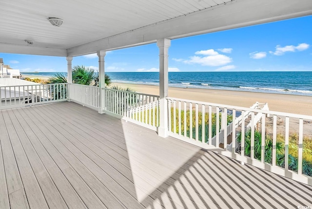 wooden deck with a water view and a view of the beach