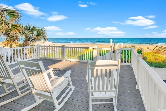 wooden terrace with a view of the beach and a water view