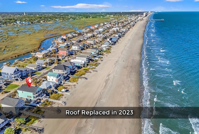 birds eye view of property featuring a water view, a residential view, and a beach view