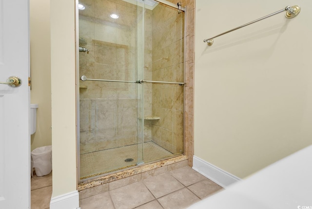 bathroom featuring a stall shower, tile patterned flooring, and baseboards