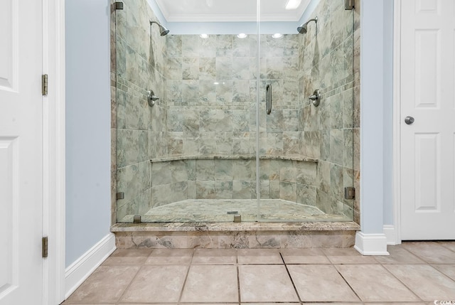 bathroom featuring a stall shower, tile patterned flooring, crown molding, and baseboards