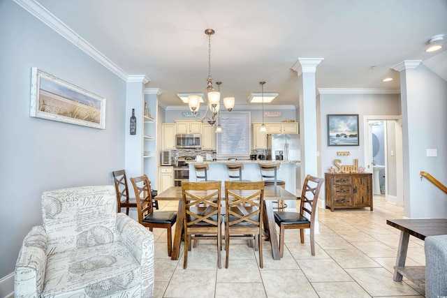 dining area with an inviting chandelier, crown molding, ornate columns, and light tile patterned floors