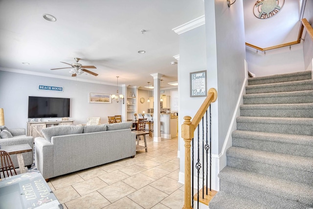 living area featuring stairway, ornamental molding, ornate columns, and light tile patterned flooring