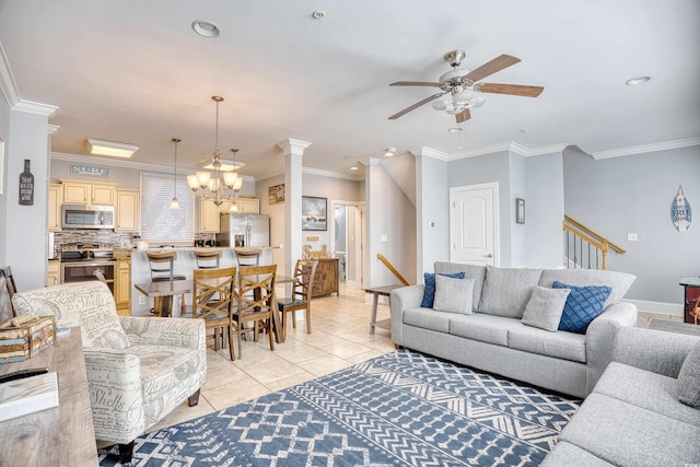 living room with ornamental molding, ceiling fan with notable chandelier, stairway, and light tile patterned floors