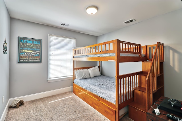 carpeted bedroom with visible vents and baseboards