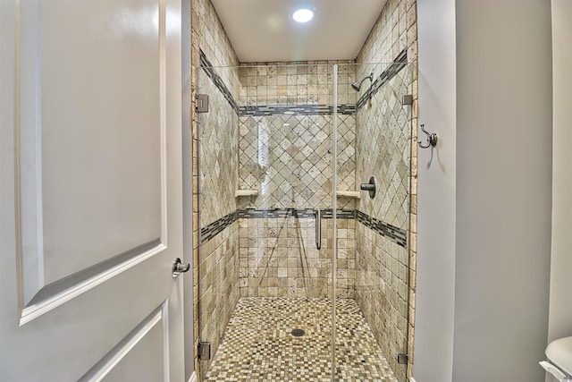 bathroom featuring a shower stall and toilet