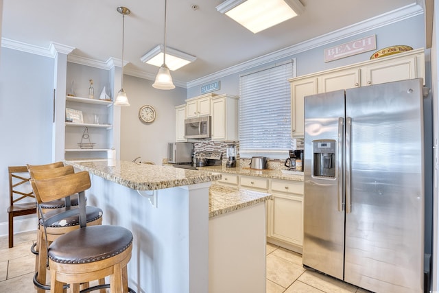 kitchen featuring ornamental molding, appliances with stainless steel finishes, cream cabinetry, light stone countertops, and tasteful backsplash