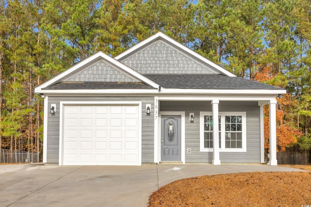 view of front of home featuring an attached garage, a shingled roof, and concrete driveway