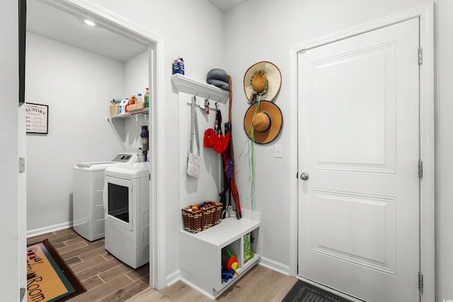 mudroom with wood tiled floor, baseboards, and washing machine and dryer