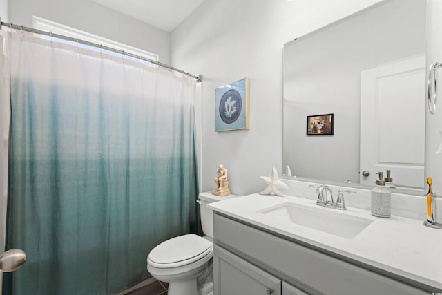 bathroom featuring a shower with shower curtain, vanity, and toilet