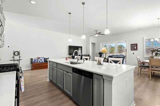 kitchen with gray cabinetry, light wood-style floors, a sink, gas range, and dishwasher