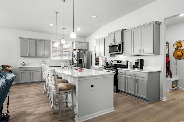 kitchen featuring light wood-type flooring, appliances with stainless steel finishes, and gray cabinets