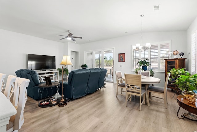 living room featuring light wood-style flooring, visible vents, and ceiling fan with notable chandelier