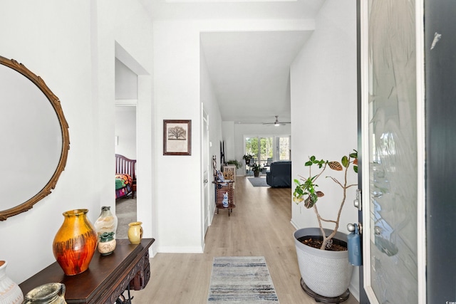 foyer featuring light wood-type flooring, ceiling fan, and baseboards