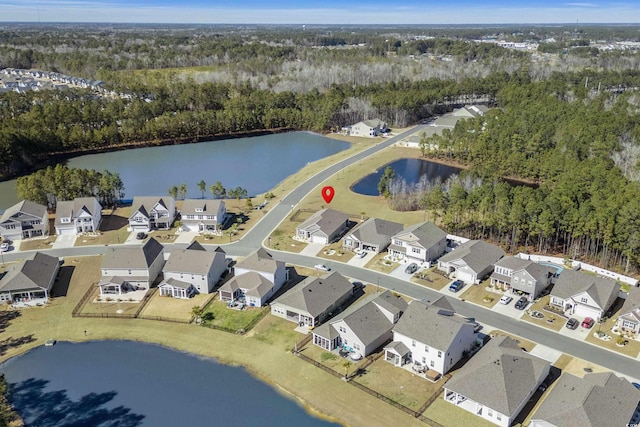 bird's eye view featuring a residential view, a water view, and a wooded view