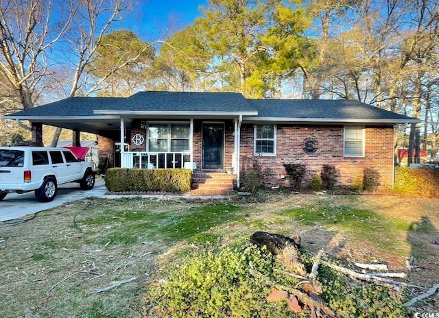 ranch-style house with covered porch, brick siding, a shingled roof, driveway, and a carport