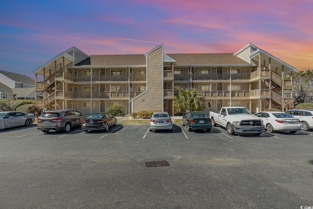 property at dusk featuring uncovered parking