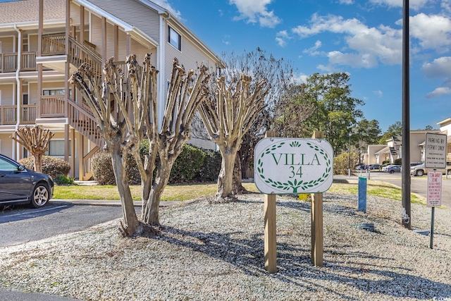 community / neighborhood sign featuring uncovered parking